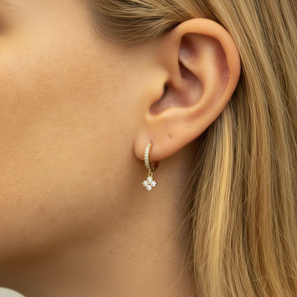 Gold hoop earrings with sparkling crystal drop charm on ear